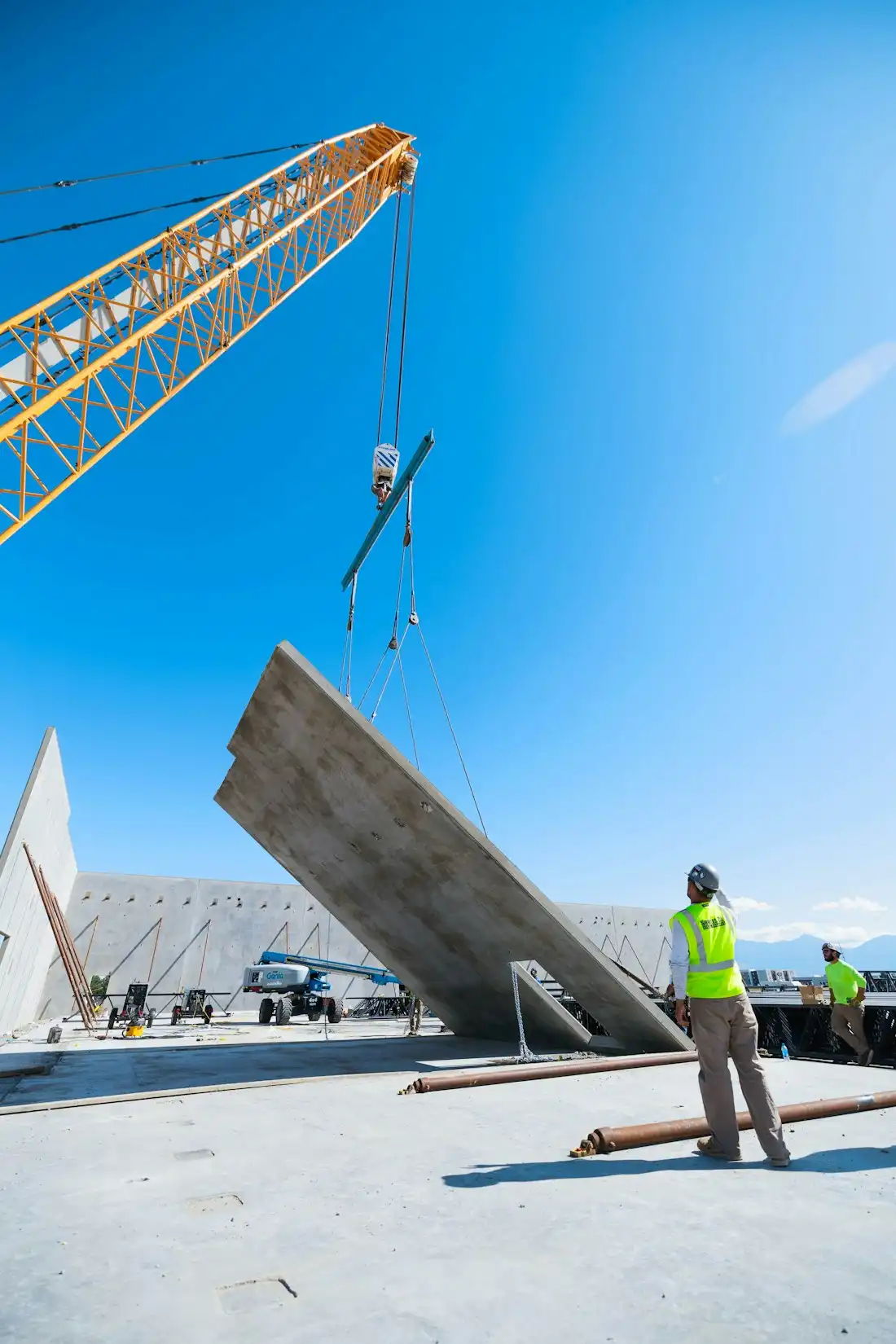 Industrial crane lifting heavy equipment at a job site